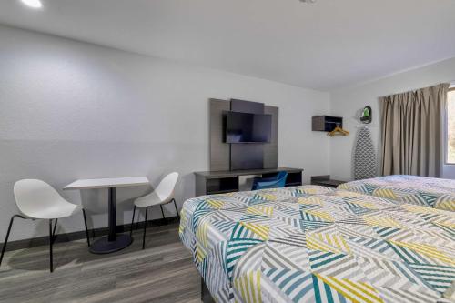 a hotel room with a bed and a table and chairs at Studio 6 Little Rock AR South in Little Rock