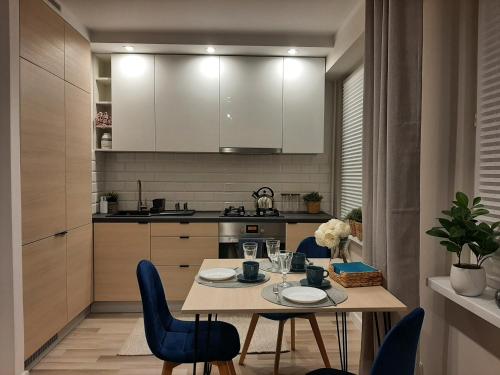 Apartament Wenecja في غروجونتس: مطبخ مع طاولة وكراسي زرقاء في الغرفة