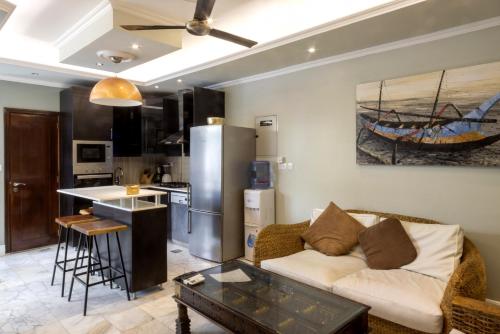 a living room with a couch and a kitchen at Dar 66 Pool Chalets with Jacuzzi in Ras al Khaimah