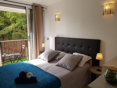 een slaapkamer met een bed met een blauwe deken en een raam bij Chez Lisa & Olivier 40 min Disney 15 min Paris Orly Airport in Athis-Mons