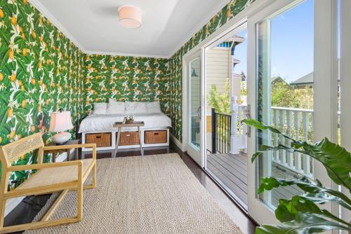 een slaapkamer met een bed op een balkon met groen behang bij Minimalistic 1885 Queen Anne Cottage 2B-2B Upper Level Flat in Alameda in Alameda
