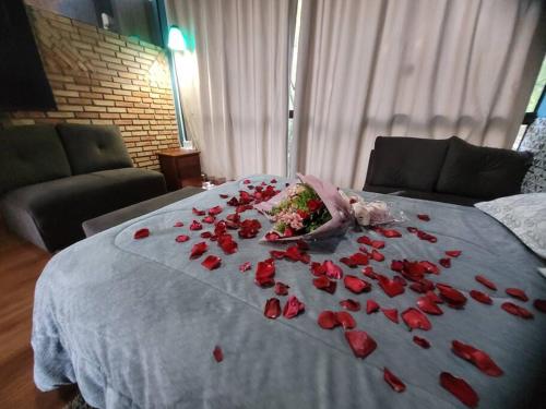 una pila de rosas rojas en una cama en Casa completa próxima a Ouro Preto! Amarantina, en Ouro Preto