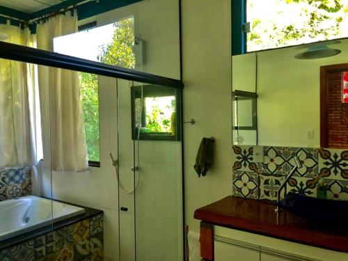 uma casa de banho com um chuveiro, um lavatório e um espelho. em Casa completa próxima a Ouro Preto! Amarantina em Ouro Preto