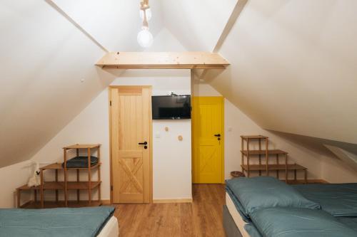 a attic room with two beds and a tv at Nasza Chata in Duszniki Zdrój