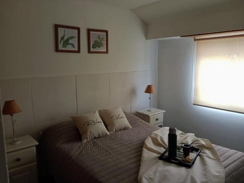 een slaapkamer met een bed en een dienblad bij AppartMaipu496 in Balcarce