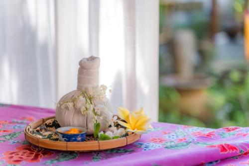 a small arrangement of flowers and a bottle on a table at Holiday Inn Express Phuket Patong Beach Central by IHG in Patong Beach