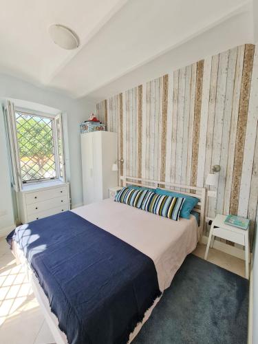 a bedroom with a large bed and a window at Villetta Fioregreco - free parking - Large outdoor space in Sanremo