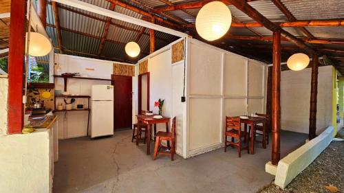 a kitchen with a table and chairs and a refrigerator at Cuarto Sol - Casa Oropopo in Cocles