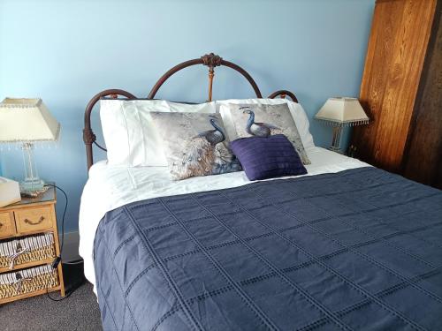 a blue bedroom with a bed with two birds on it at Connemara Country Lodge in Awhitu