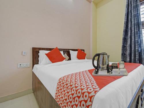 a hotel room with a bed with a tea kettle on a table at Hotel O Kalot in Jaipur