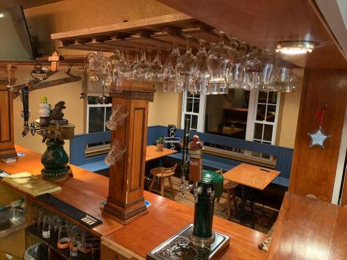 un bar con copas de vino colgando del techo en The Lunablu Lodge Sunday River, en Bethel