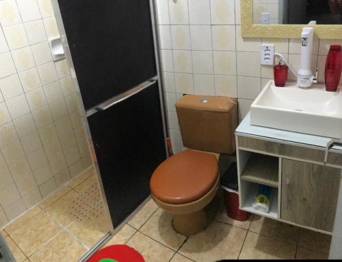 a bathroom with a toilet and a sink at Apartamento familiar com estacionamento in Porto Alegre