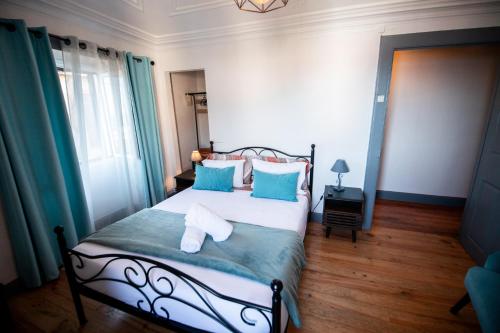 um quarto com uma cama com almofadas azuis e brancas em Casa das Vistas em Porto Moniz
