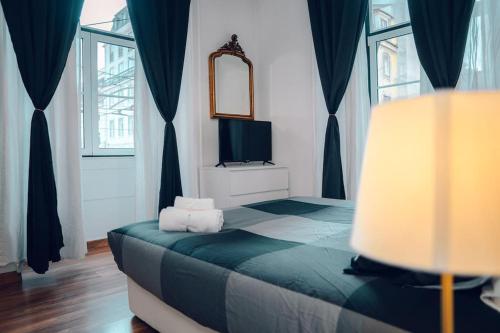 um quarto com uma cama com um espelho e uma televisão em Sinta o Coração Lisboeta em Lisboa