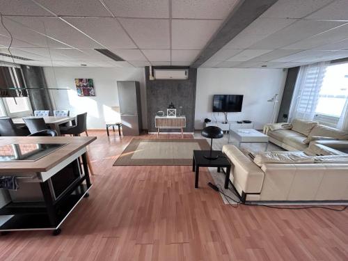 a living room with a couch and a tv at Loft Exclusif 100m2 in Grimbergen