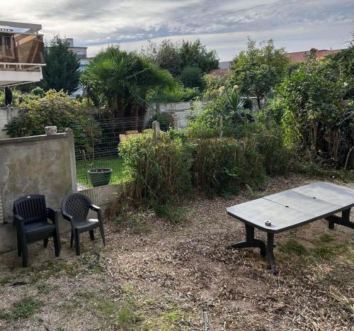 a picnic table and two chairs in a yard at Loft Exclusif 100m2 in Grimbergen
