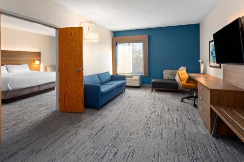 ein Hotelzimmer mit einem Bett und einer blauen Wand in der Unterkunft Holiday Inn Express - New Albany in New Albany