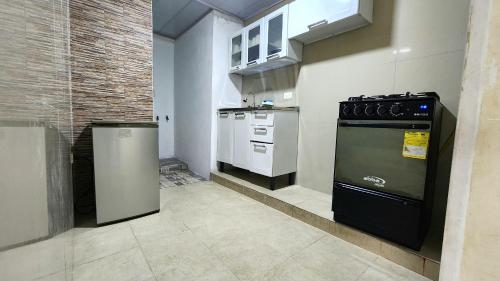 a kitchen with a black stove and white appliances at Excelente Apartamento Confortable, Central, Bonito y Económico in El Espinal
