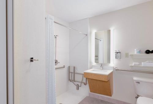 a white bathroom with a sink and a shower at Candlewood Suites Oklahoma City-Moore, an IHG Hotel in Moore