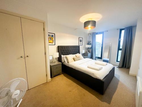 a bedroom with a large bed with a black headboard at Shard views in London