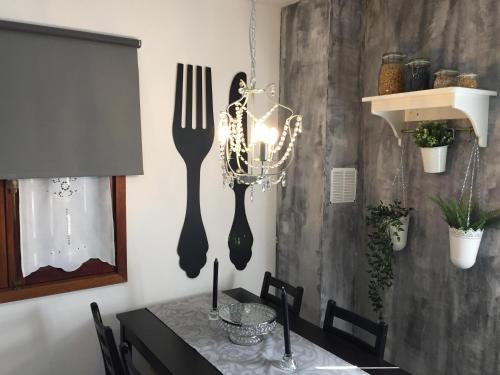 a dining room table with two forks and a chandelier at Casa do Lago in Amarante