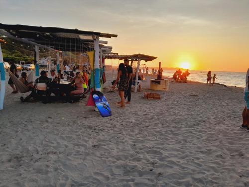 un gruppo di persone sulla spiaggia al tramonto di Hostal Fara a Jama