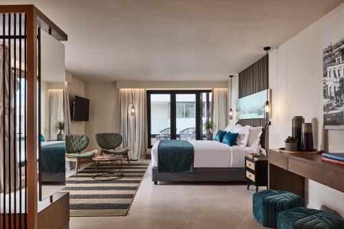 a hotel room with a bed and a living room at Athenarum Portus Life & Style Hotel in Piraeus