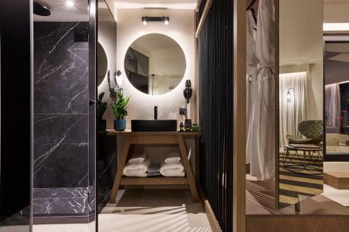 W łazience znajduje się umywalka i lustro. w obiekcie Athenarum Portus Life & Style Hotel w Pireusie