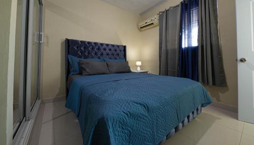 a bedroom with a blue bed with a blue comforter at APARTAMENTO FRANCO in Santo Domingo