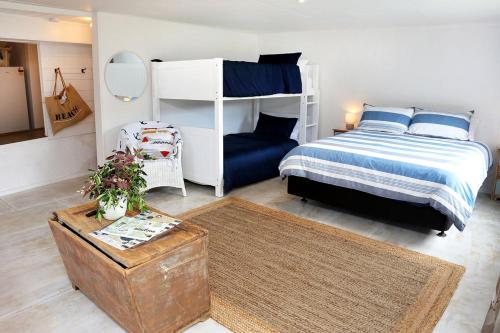 1 dormitorio con 1 cama y 1 litera en The Cowshed, en Whitianga