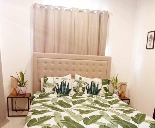 a bedroom with a bed with plants on it at Home away from home. in Bacolod