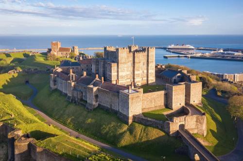 eine Luftansicht eines Schlosses mit dem Meer dahinter in der Unterkunft Dover Castle Luxury Apartments in Kent