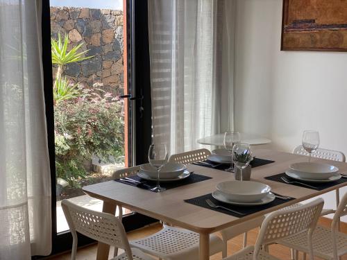 a dining room table with chairs and a table and a window at Villas Quintero in Tinguatón