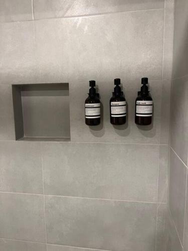 three bottles on a shelf in a bathroom at Departamento centrico in Guadalajara