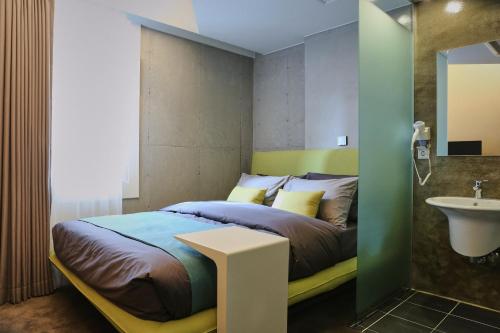 a bedroom with a bed and a sink at Hotel Cocomo in Seoul