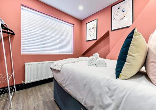 a bedroom with orange walls and a bed with two clocks at Bright & Colourful House - Best for a Large Groups in London