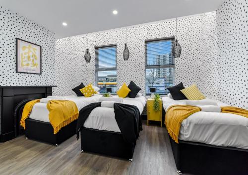 a bedroom with two beds with yellow blankets at Bright & Colourful House - Best for a Large Groups in London