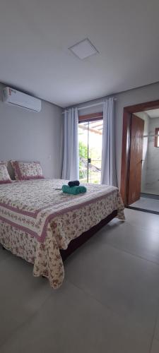 a bedroom with a bed in a room with a window at White House - Taipú de Fora in Barra Grande