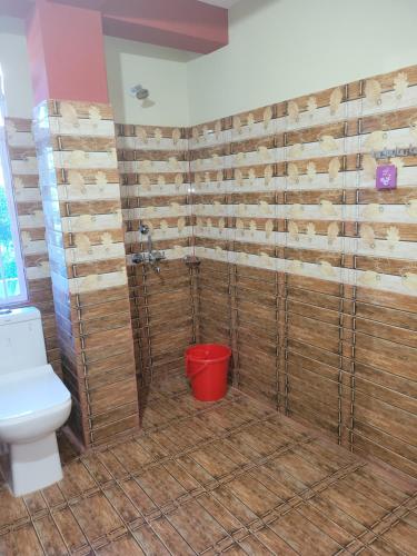 a bathroom with a toilet and wooden walls at Vati guesthouse in Shillong