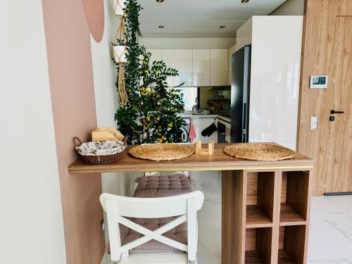 a kitchen with a table and a white chair at Superbes Appartements Chics, Cosy, neufs et idéalement situés ! in Casablanca