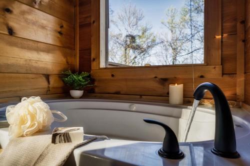 a bathroom with a tub and a sink at Updated Serene Mtn Cabin, theater rm & popcorn! in Sevierville
