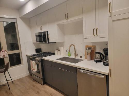 a kitchen with a sink and a stove at Amazing big studio near Balboa Park Jacuzzi rooftop free parking! in San Diego