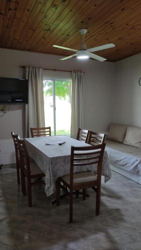 una sala da pranzo con tavolo, sedie e un letto di Alojamiento Dimar a Villa Elisa