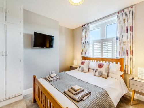 1 dormitorio con 1 cama grande y ventana en Wharfedale Cottage, en Harrogate
