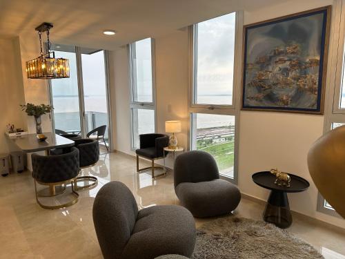 a living room with chairs and a table and windows at Departamento chic Costanera Posadas in Posadas