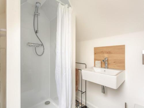 a white bathroom with a sink and a shower at East Tarrel Cottage in Portmahomack