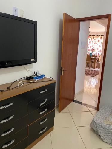 a bedroom with a tv and a dresser with a television on it at Casa com piscina- condomínio verão vermelho II UNAMAR CABO FRIO in Cabo Frio
