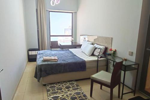 ocean view Dubai Marina JBR walk comfort room في دبي: غرفة نوم بسرير وكرسي ونافذة