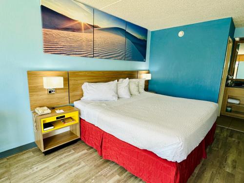1 dormitorio con 1 cama grande y pared azul en Days Inn by Wyndham Las Cruces en Las Cruces