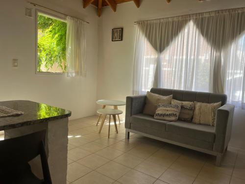 ein Wohnzimmer mit einem Sofa und einem Tisch in der Unterkunft La calma in Puerto Madryn